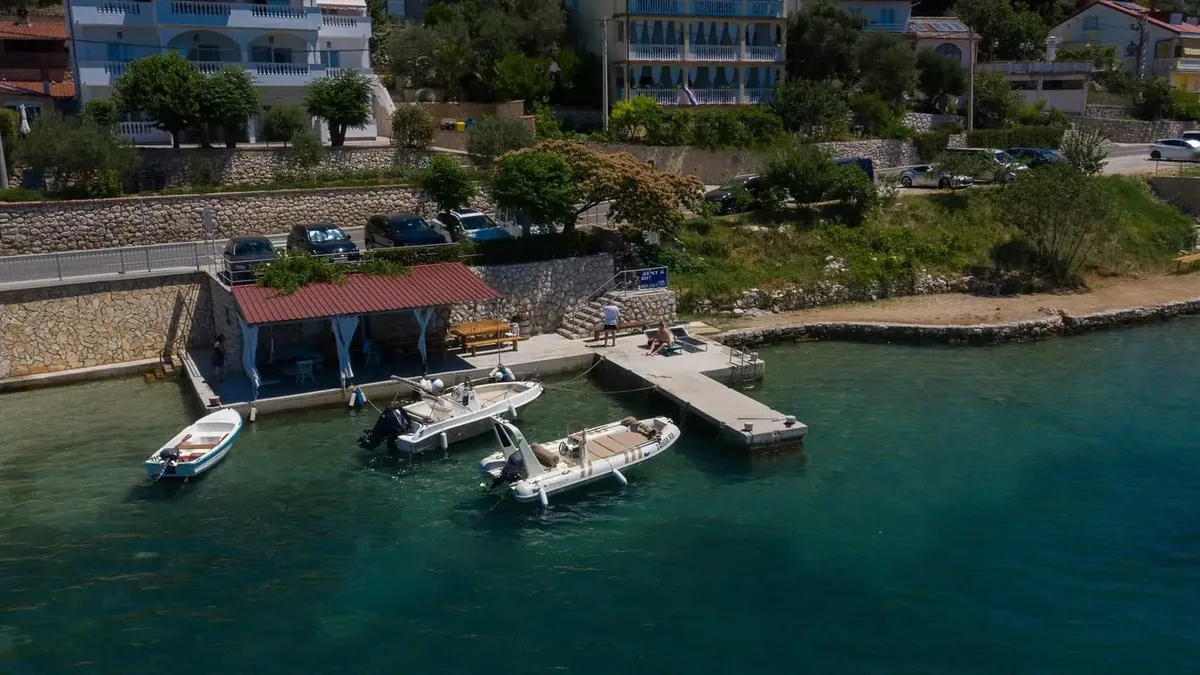 Die Uferanlage der Villa Sylvie mit Apartments im Hintergrund und Booten an ihren Liegeplätzen in Supetarska Draga.